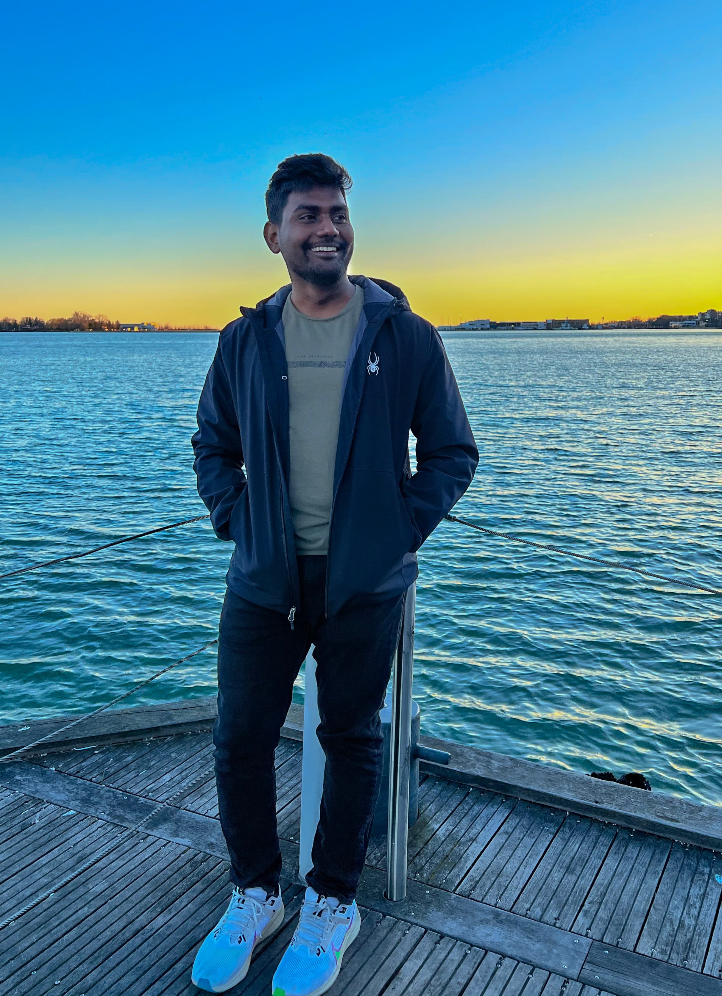 Siva standing on a waterfront at sunset in Vancouver